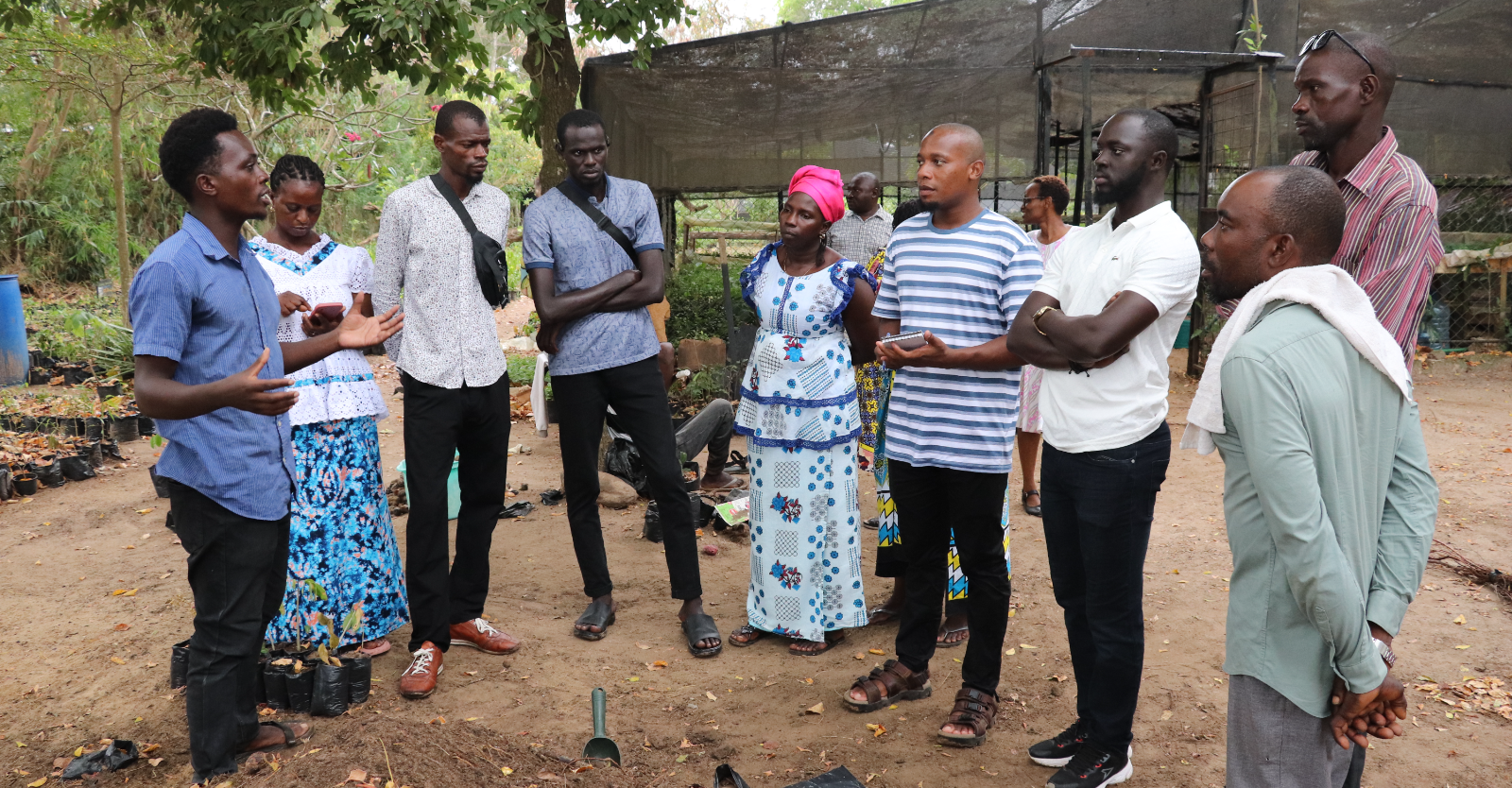 Tree nursery farmer at Pwani University demonstrates nursery bed preparation to visiting farmers from Senegal.
